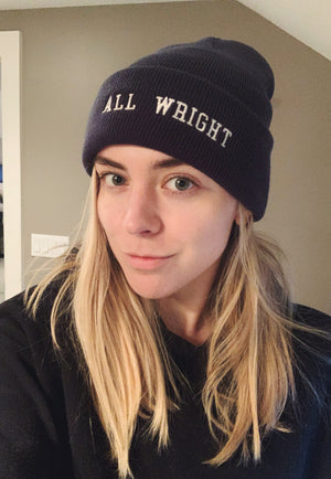 Woman wears navy "ALL WRIGHT" beanie with white letters - inspired by Villanova University College Basketball Coach, Jay Wright